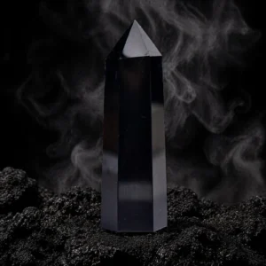 Obsidian crystal point on grounding altar with dark smoky background