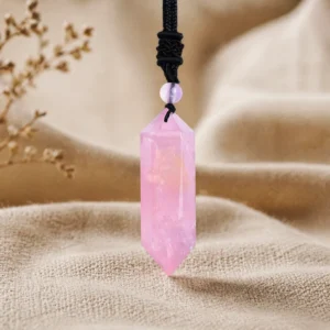 Rose Quartz pendant hanging on silver chain above dark gray suede fabric for elegant jewelry display
