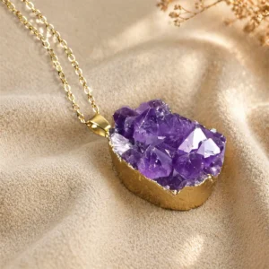 Amethyst pendant hanging on silver chain above dark gray suede fabric for elegant jewelry display