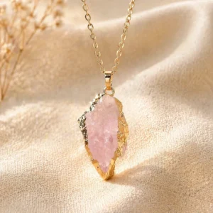 Rose Quartz pendant on dark gray velvet surface, heart chakra love crystal jewelry